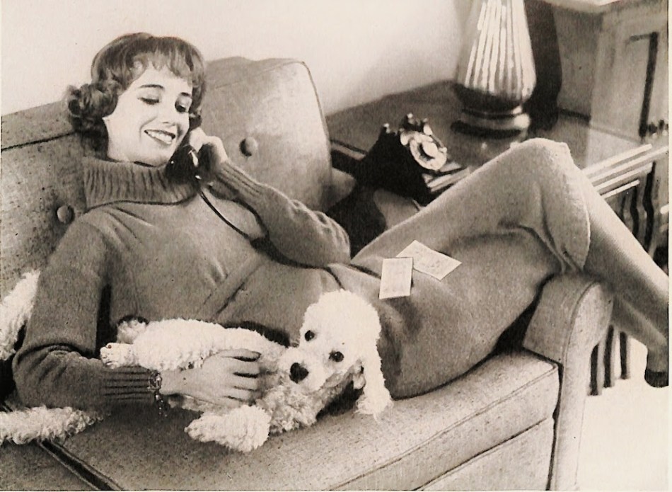 1950s teen talking on phone while holding poodle.