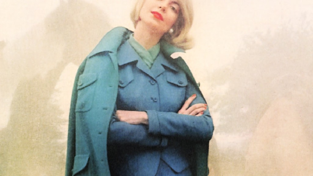 1950s woman wearing coat in peacock blue worn over a suit in a similar color.